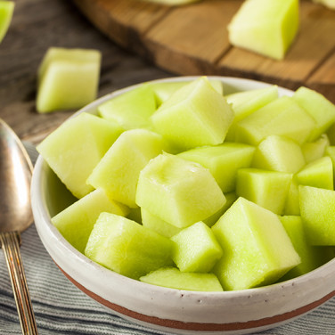 sliced open honeydew on wooden cutting board