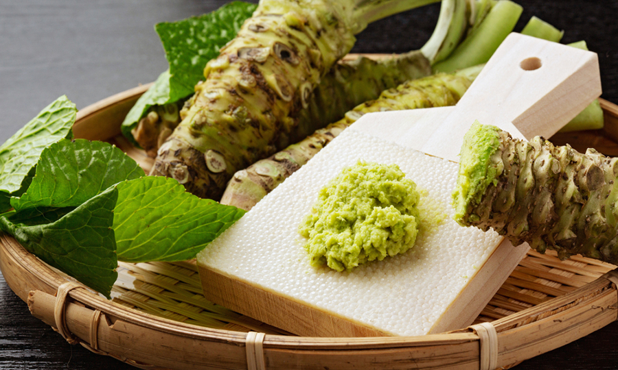 bamboo tray with wasabi roots and spoonful of wasabi paste on tray