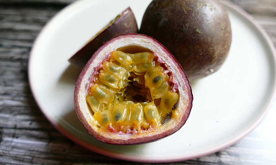 ripe passion fruit sliced in half on plate