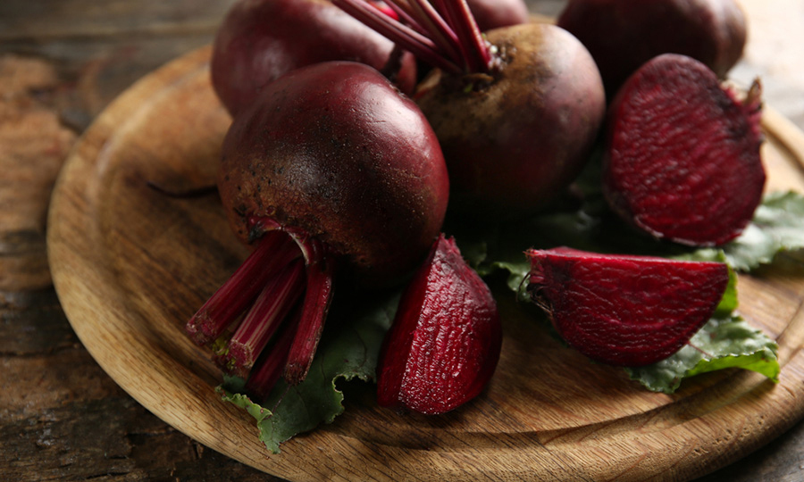fresh beets cut and plated on wooden dish