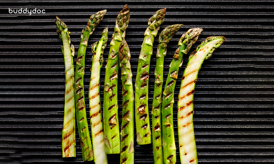 asparagus stalks with charred grill marks on metal grill surface