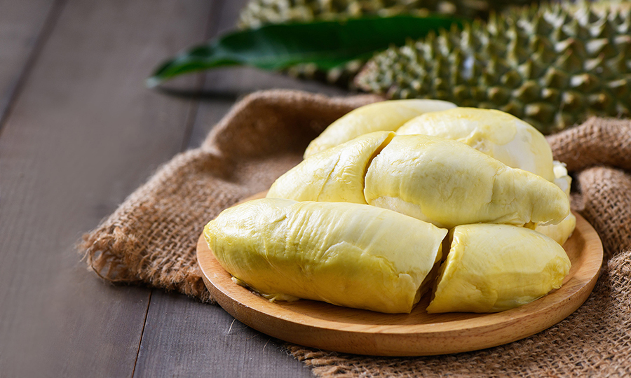 A wooden tray with a pile of durian flesh laid on top